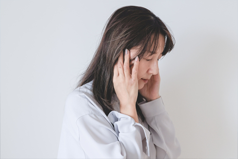耳を抑える女性